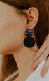 Woman profile modeling large black statement earring